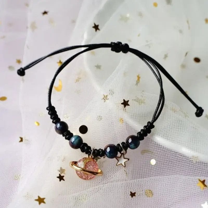 bracelet fantaisie planete avec anneau dore et perles colorees corde noire et planete rose 800 1