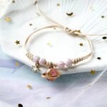 bracelet fantaisie planete avec anneau dore et perles colorees corde rose et planete 762 1