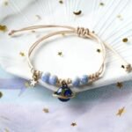 bracelet fantaisie planete avec anneau dore et perles colorees corde rose et planete bleu 159 1