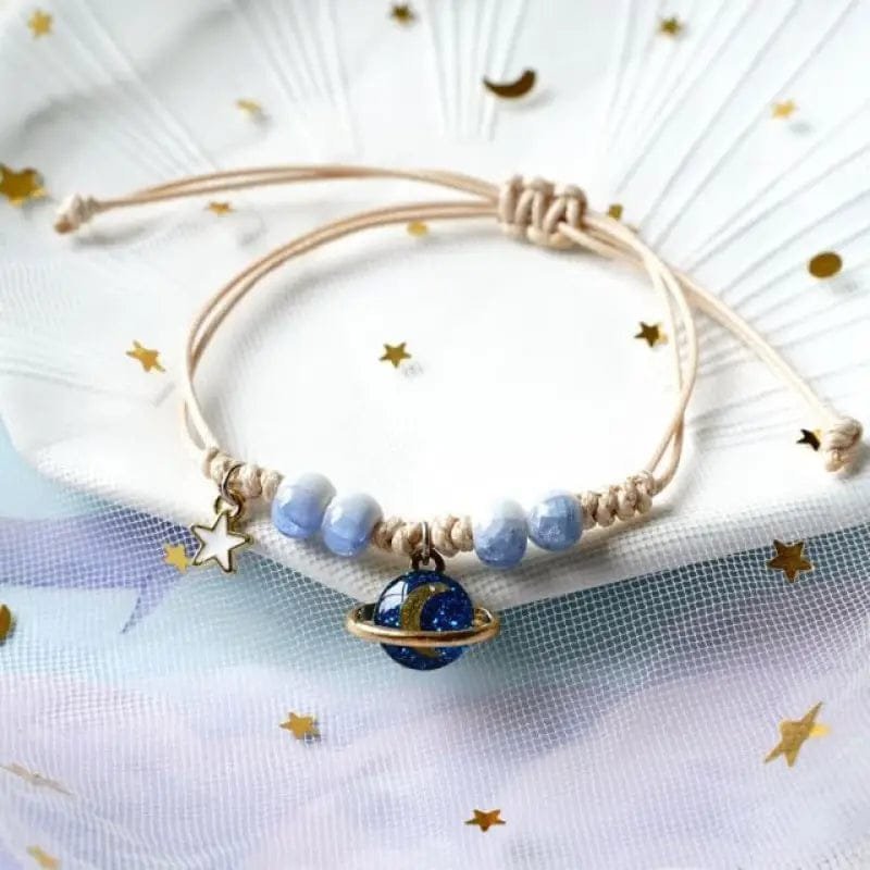 bracelet fantaisie planete avec anneau dore et perles colorees corde rose et planete bleu 159 1