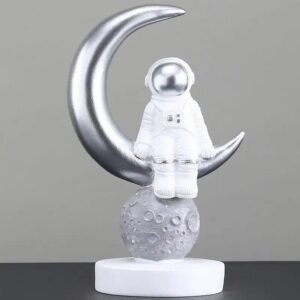 figurine astronaute assis sur croissant de lune en resine argentee 985 1